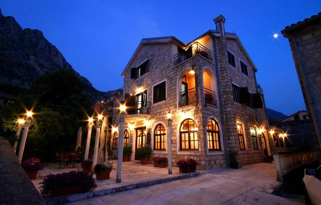 Vila Panonija stone building in Dobrota, Kotor, lit at dusk
